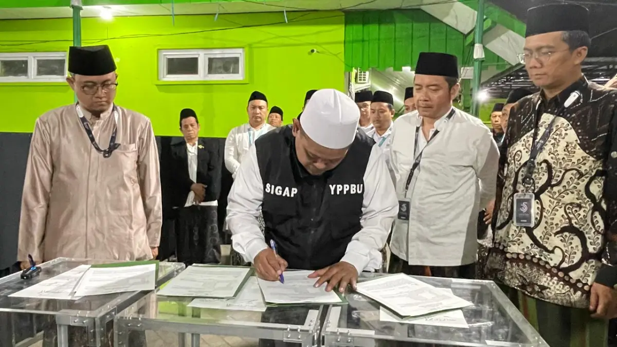 TRANSPARAN: Ketua Panlok Muktamar ke-35 NU KH Abdurrozaq Sholeh menandatangani berita acara penerimaan surat rekomendasi nama-nama calon AHWA di halaman MTs Bahrul Ulum Tambakberas, Jombang. (Chariris/JPRM)