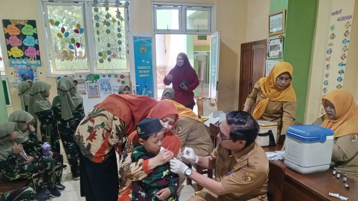 SISIR SASARAN: Petugas puskesmas melaksanakan imunisasi siswa di salah satu lembaga pendidikan di Kecamatan Mojosari. (Indah JPRM)