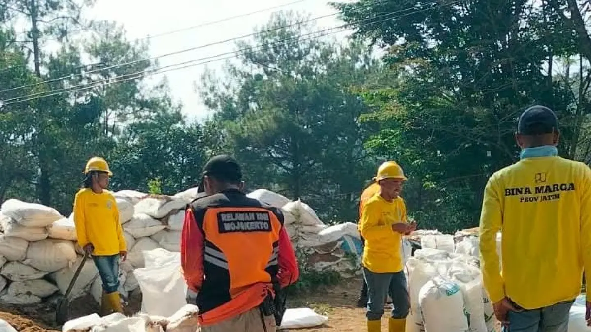 PEDULI: Relawan yang tergabung di FPRB Kabupaten Mojokerto bahu-membahu memperbaiki karung sekam pada dinding penyelamat di rest area Sendi, Desa/Kecamatan Pacet. (dok JPRM)