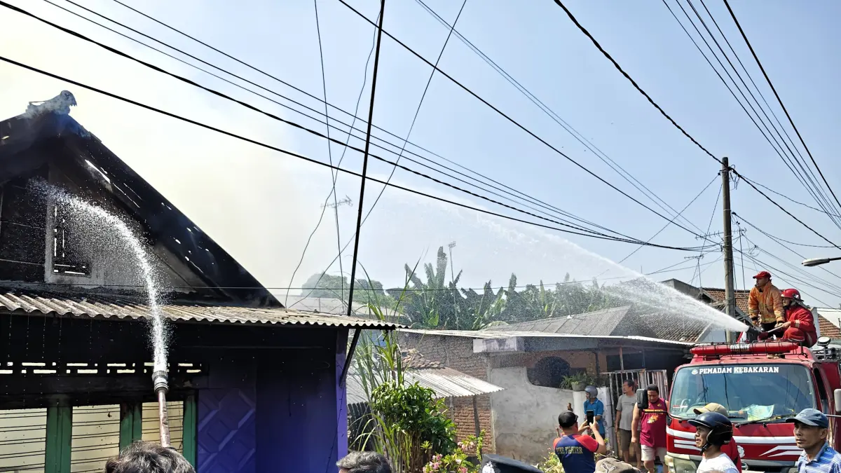 BERJIBAKU: Petugas damkar memadamkan rumah warga di Jalan Mentikan Gang 1, Kelurahan Mentikan, Kecamatan Prajurit Kulon yang terbakar, Minggu (6/9) pagi. (Martda/JPRM)
