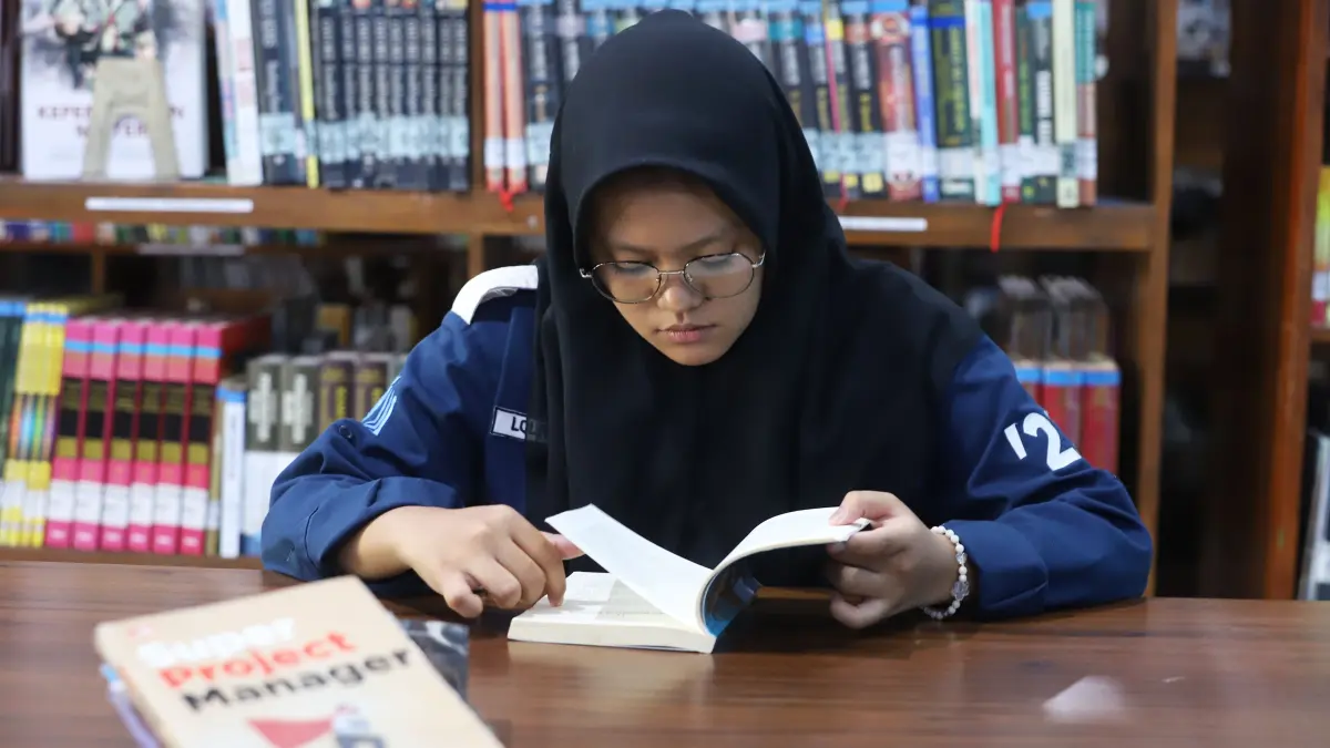MEMBACA: Lolita, 21, Mahasiswa asal malang asyik membaca di Perpustakaan Daerah Kota Mojokerto, Senin (7/9). (Sofan Kurniawan/JPRM)
