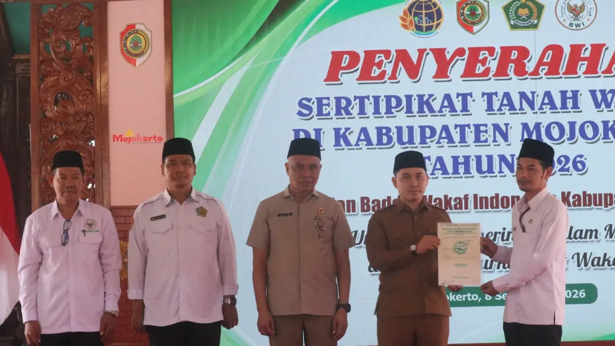 LEGALITAS ASET: Bupati Mojokerto Muhammad Albarraa didampingi Kepala Kanwil BPN Provinsi Jawa Timur Muhammad Naim menyerahkan sertifikat tanah wakaf kepada perwakilan lembaga keagamaan dan pendidikan di Pendapa Graha Majatama Pemkab Mojokerto, Selasa (8/9). (Dori/JPRM)