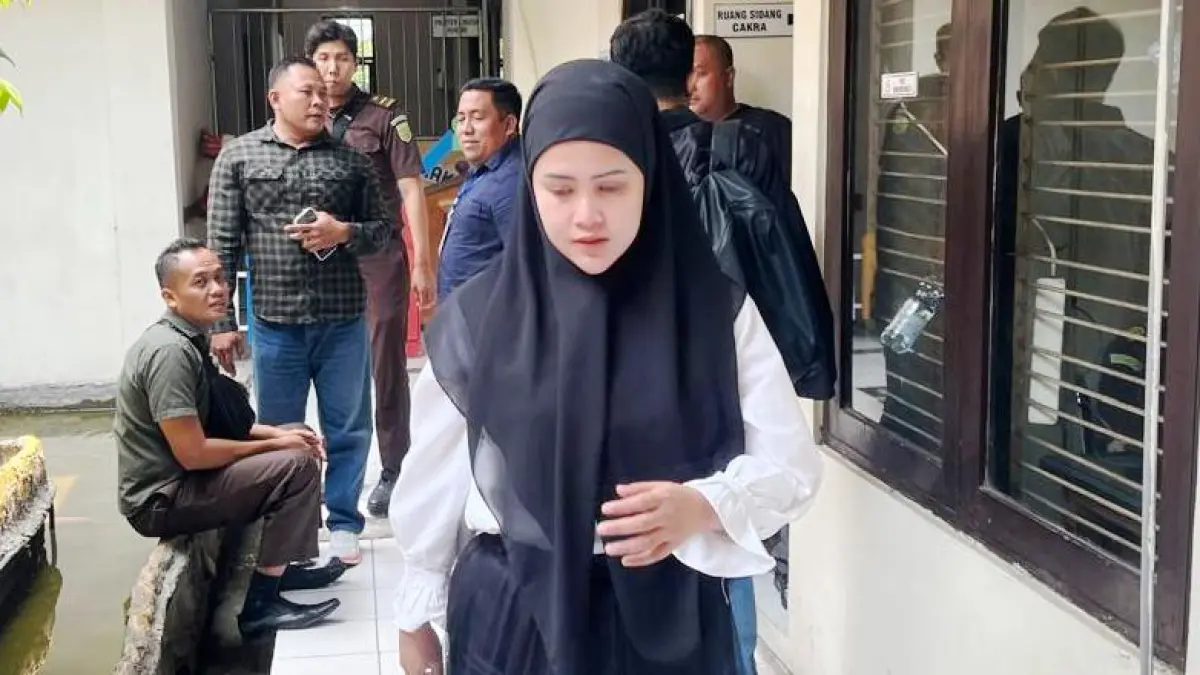TIPU MUSLIHAT: Terdakwa penipuan dengan modus slot lelang arisan online, Ernawati, usai menjalani sidang di Pengadilan Negeri Mojokerto, Selasa (8/9). (Farisma/JPRM)