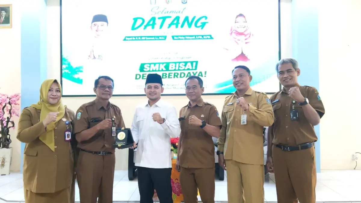 KOLABORASI: Staf Khusus Menteri Desa dan PDT RI M. Afif Zamroni didampingi Kepala Cabdindik Jatim Wilayah Kabupaten dan Kota Mojokerto Pinky Hidayati saat penyerahan cendera mata usai peluncuran program SMK Bisa, Desa Berdaya, di SMKN 1 Jatirejo, Senin (14/9). (Indah/JPRM)