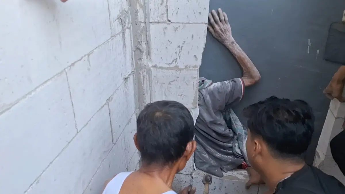 DRAMATIS: Warga berupaya mengevakuasi Dimyati yang terjepit di antara bangunan tembok di Desa Ngrame, Kecamatan Pungging, Kabupaten Mojokerto, Selasa (15/9). (Rizal/JPRM)