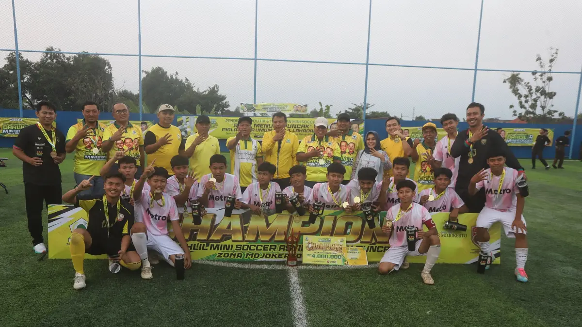 SANG JUARA: Tim mini soccer SMAN Ngoro, Jombang bersama jajaran tim penyelenggara Turnamen Bahlil Mini Soccer, pengurus DPD Golkar Jatim, DPD Golkar Kabupaten/Kota Mojokerto, dan Kabupaten Jombang seusai penyerahan piala juara pertama final zona Mojokerto-Jombang di Asri Sport Centre, Desa/Kecamatan Ngoro, Kabupaten Mojokerto, Jumat (18/9). (Sofan Kurniawan/JPRM)