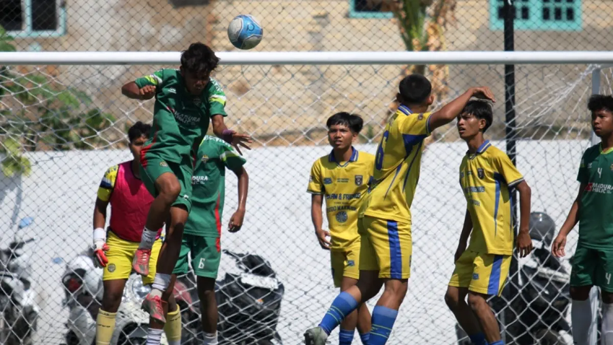 KETAT: Pemain MAN 2 Pamekasan (jersey hijau) menghalau bola atas saat mendapat serangan dari pemain-pemain SMAN 4 Pamekasan di Turnamen Bahlil Mini Soccer Asyik Menuju Puncak Zona 8 Madura di Puri Dewata Mini Soccer Pamekasan, Jumat (25/9). &nbsp;(FAHMI JALIL/RADAR MADURA)