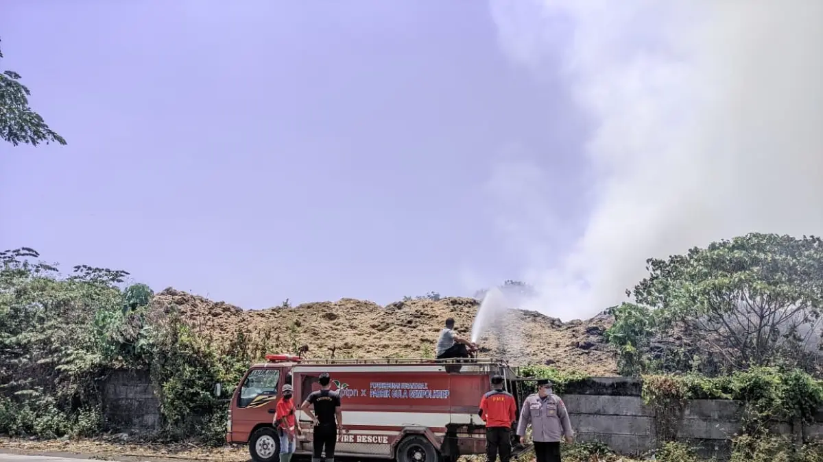 PEMADAMAN: Petugas gabungan berupaya memadamkan api yang membakar tumpukan sekam ampas tebu PT Sinergi Gula Nusantara (SGN) PG Gempolkrep, Desa/Kecamatan Gedeg, Sabtu (26/9) siang.&nbsp;(Martda/JPRM)