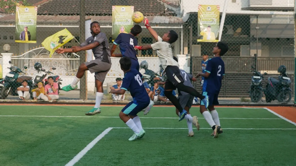 BEREBUT DI UDARA: Pemain SMAN Rambipuji Yunus Fefanya Babingga (kiri), berebut bola atas dengan kiper SMKN 2 Jember dalam pertandingan semifinal Bahlil Mini Soccer Zona 10 Jember, kemarin sore (2/10). Pertandingan itu dimenangkan SMAN Rambipuji dengan skor 2-1. (SIDKIN ALI/RADAR JEMBER)