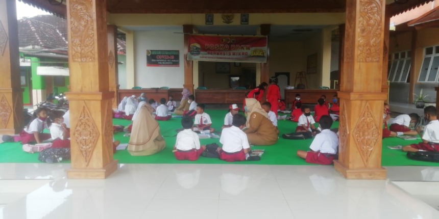 DARURAT: Siswa SDN Watesprojo, Kecamatan Kemlagi menjalani proses pembelajaran di balai desa setempat, kemarin. Banjir yang merendam gedung sekolah mereka belum surut.