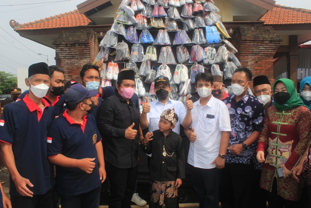 UNGGULAN: Kepala Desa Medali Miftahuddin (peci hitam) bersama Menteri Desa Gus Halim (topi hitam-tengah) berfoto bersama berlatar produk unggulan Desa Medali yakni kerajinan sepatu.