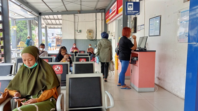 PRAKTIS: Salah satu calon penumpang yang hendak berangkat mencetak tiket perjalanan kereta api di Stasiun Mojokerto, kemarin.