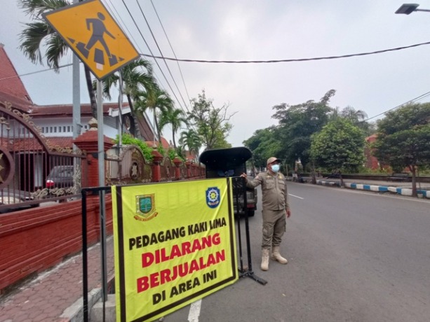 STERIL: Petugas Satpol PP Kota Mojokerto berjaga di jalur sisi timur Alun-Alun Kota Mojokerto untuk menghalau PKL kemarin.