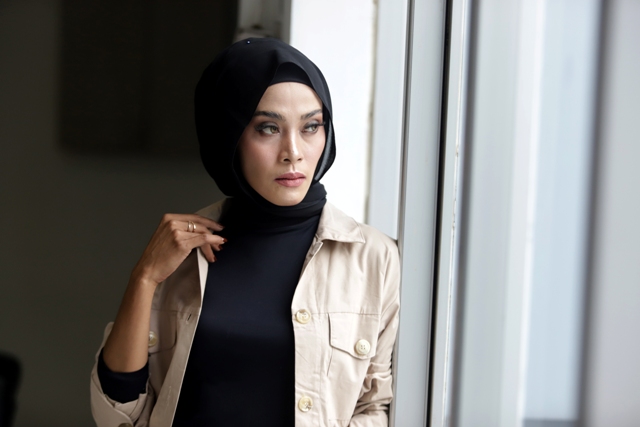 Seorang model peragakan jilbab pashmina tanpa peniti.
