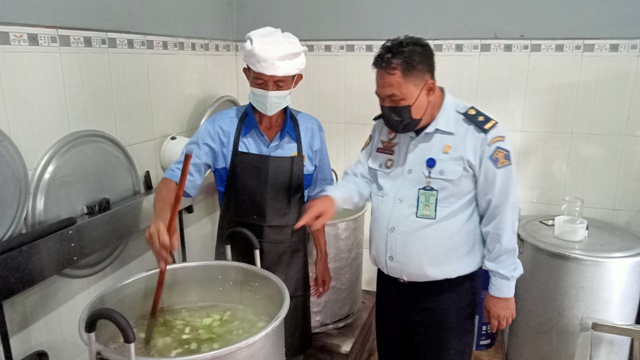 DIOLAH: Ariyanto didampingi salah satu petugas Lapas saat proses memasak sayur yang hendak disajikan ke para napi lainnya jelang berbuka puasa di dapur Lapas Klas IIB Mojokerto, Selasa lalu (5/4).