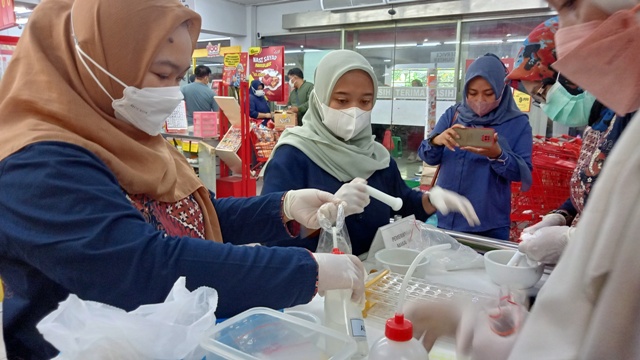 AMBIL SAMPEL: Petugas Dinkes PPKB Kota Mojokerto menguji kandungan salah satu sampel produk mamin di salah satu swalayan, kemarin.