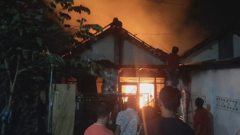 KEBAKARAN: Rumah di Kelurahan Blooto yang dilalap si jago merah tengah berusaha dipadamkan warga dan petugas.