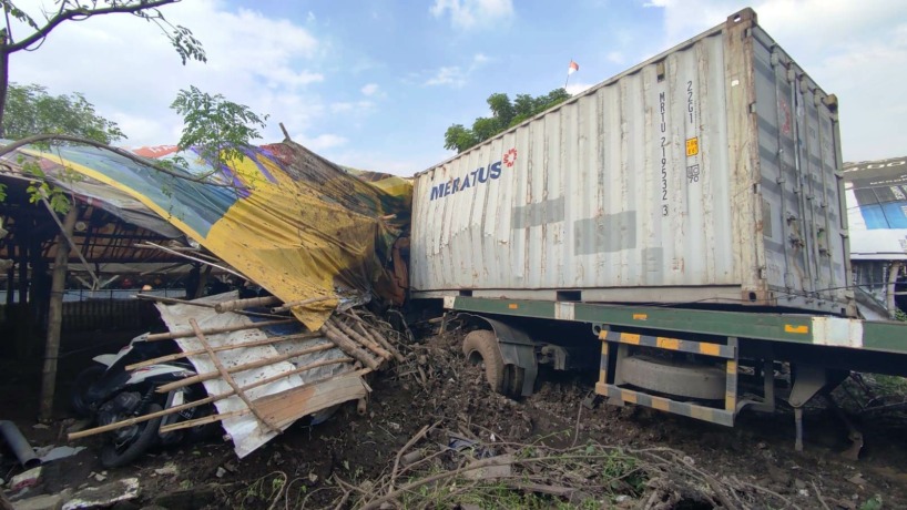 NYELONONG: Truk kontainer bernopol S 9818 UN rusak parah akibat menghantam pembatas jalan dan parkiran motor karena mengalami rem blong di kawasan NIP Dusun Sukorejo, Desa Lolawang, Kecamatan Ngoro, kemarin.
