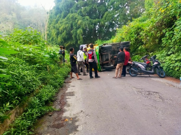 TERGULING: Truk warna kuning bernopol N 8817 UV yang gagal menanjak hingga terguling di Jalur Cangar, Kecamatan Pacet. (Dok Welirang Community for Jawaposradarmojokerto)