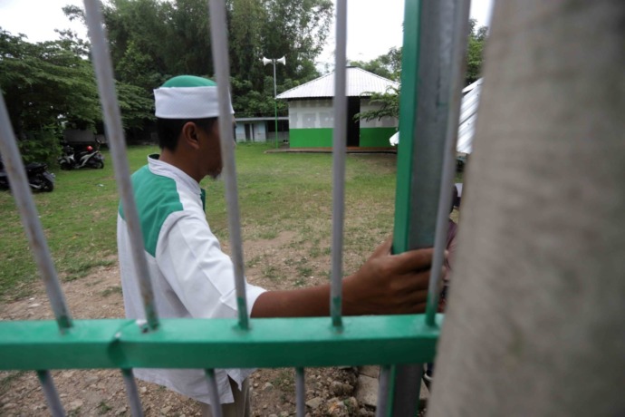 DIJAGA KETAT: Petugas melakukan penjagaan di ponpes Khilafatul Muslimin di Dusun Pandanrejo Desa Simbaringin Kecamatan Kutorejo Kabupaten Mojokerto, Senin (13/6), ponpes itu dijaga ketat setelah salah satu pimpinan dari ormas Khilafatul Muslimin berinisia