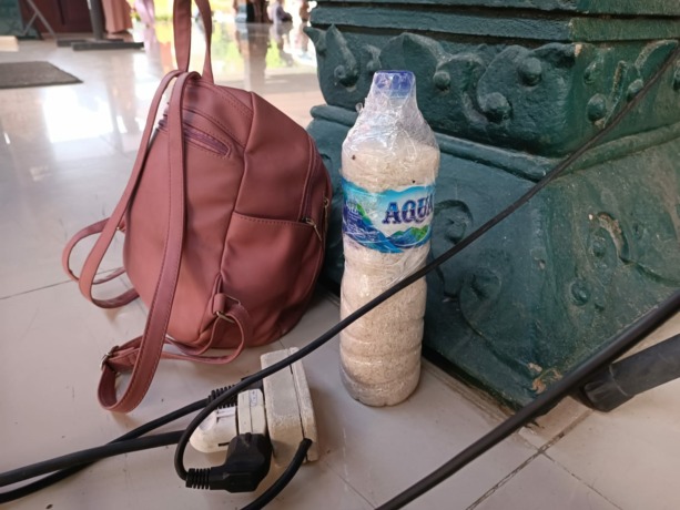 BARANG TERLARANG: Botol air mineral yang berisi beras disita petugas dari dua koper CJH Mojokerto, tadi pagi.