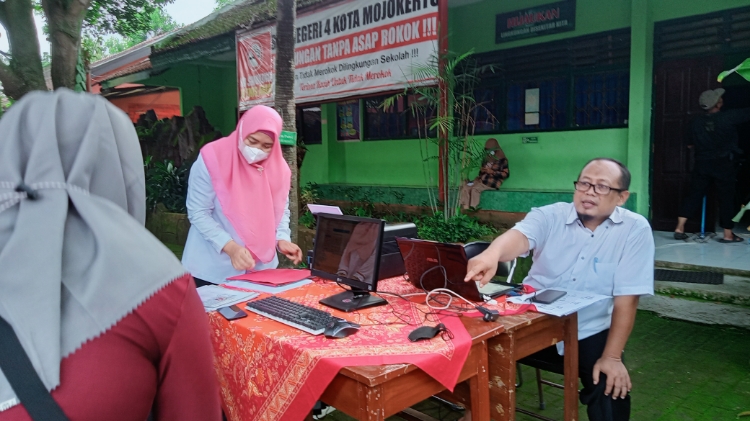 PPDB KOTA: Petugas PPDB SMPN 4 Kota Mojokerto memberikan penjelasan pada salah satu wali murid terkait mekanisme PPDB, Rabu (8/6). (Indah Oceananda/Jawaposradarmojokerto.id)