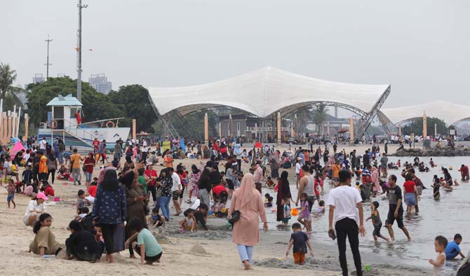 Masyarakat melakukan wisata di Pantai Ancol, Jakarta, Kamis (26/5/2022). Sejumlah tempat wisata termasuk Ancol ramai dikunjungi masyarakat bersama keluarganya untuk mengisi hari libur. FOTO : FEDRIK TARIGAN/ JAWA POS