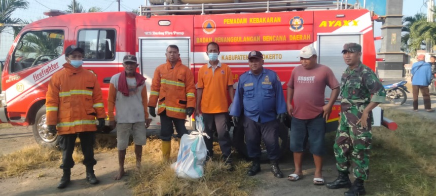 BIKIN RESAH: Petugas Damkar Kabupaten Mojokerto memindahkan ular yang berada di kandang ayam warga Dusun Gempol, Desa Wunut, Kecamatan Mojoanyar, kemarin.