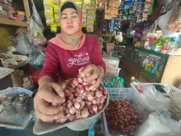 MEROKET: Mustika salah satu pedagang di Pasar Pelabuhan, Kecamatan Jetis saat melayani pembeli bawang merah.