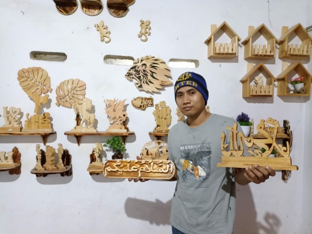 KREATIF: Mubin Supanji menunjukkan hasil kerajinan tangannya di rumahnya Desa Gunungsari, Kecamatan Dawarblandong, Jumat (17/6).