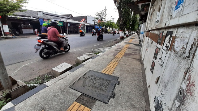 TAK RAMPUNG: Sisa pekerjaan jalur pedestrian yang belum tuntas pasca putus kontrak proyek rehabilitasi saluran dan trotoar di Jalan Mojopahit, Kota Mojokerto.