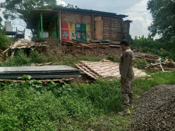 DALAM PENGAWASAN: Petugas Satpol PP Kabupaten Mojokerto saat membantu porses pembongkaran empat warung remang-remang di Desa Awang-Awang, Kecamatan Mojosari.