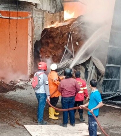 PEMADAMAN: Sejumlah petugas masih berupaya memadamkan kebakaran di pabrik minyak kelapa PT Indo Oil Perkasa, Tbk di Jalan Raya Perning No 39, Desa Perning, Kecamatan Jetis, Kabupaten Mojokerto, siang ini. (Yulianto Adi Nugroho/Jawaposradarmojokerto.id)