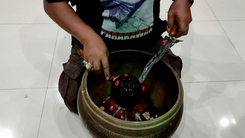 KHUSYUK: Proses pencucian keris pusaka saat penjamasan di peringgitan Pemkab Mojokerto pada peringatan malam saru Suro, Jumat (29/7). (Yulianto Adi Nugroho/Jawa Pos Radar Mojokerto)