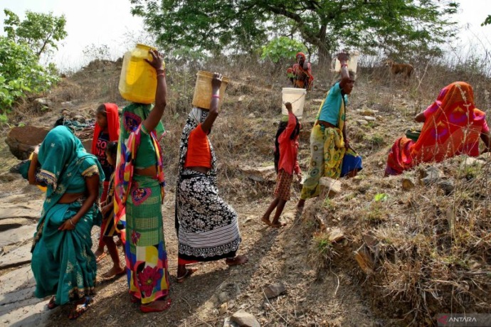 Arsip - Sejumlah wanita membawa wadah air setelah mengisinya dengan air di sebuah tambang batu yang ditinggalkan pada saat cuaca panas, di desa Badama, di negara bagian utara Uttar Pradesh, India, Rabu (4/5/2022). ANTARA FOTO/Reuters-Ritesh Shukla/hp.​​​​