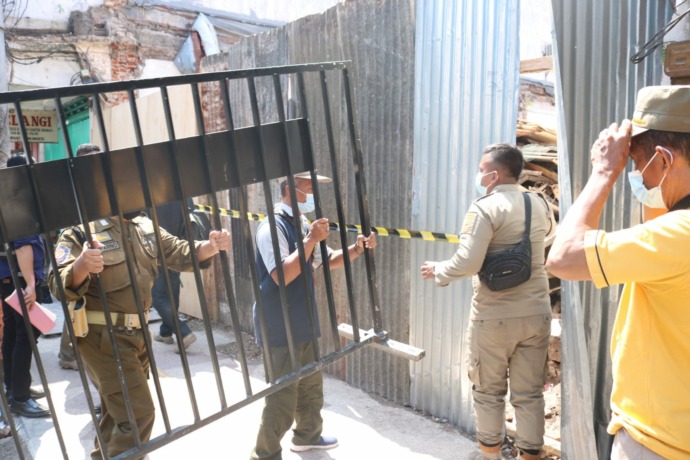 BANDEL: Satpol PP Kota Mojokerto memasang barikade dan garis satpol PP di lokasi proyek ruko yang sebelumnya sudah disegel, kemarin.