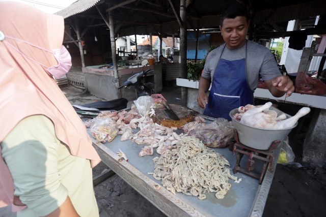 DAGING AYAM: Seorang pembeli tengah mengantri mendapatkan daging ayam di stan penjual Pasar Tanjung Anyar, Kota Mojokerto, Jumat (15/7). (Sofan Kurniawan/jawaposradarmojokerto.id)