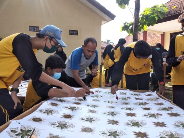 GOTONG ROYONG: Siswa SMA Negeri 1 Sooko saat proses membuat batik cap yang bakal dikenakan sebagai seragam didampingi guru pembimbing.