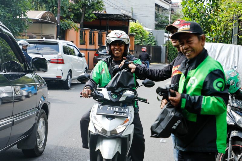 Seorang pengurus Komunitas Warung Tegal (Kowarteg) Indonesia membagikan makanan gratis kepada salah satu pengendara di Jakarta, Senin (1/8/2022). ANTARA/HO-Kowarteg Indonesia