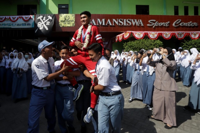 SEMARAK: Para pelajar SMA Taman Siswa menyambut kedatangan Tegar Islami yang menjadi pemain Timnas U-16 yang baru saja menjuarai ajang Piala AFF Cup 2022 di Yogyakarta, tadi pagi. (Sofan Kurniawan/Jawa Pos Radar Mojokerto)