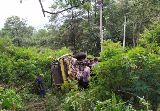 TERGULING: Petugas Polsek Pacet tengah memeriksa kecelakaan tunggal di tempat kejadian perkara (TKP). (dok Relawan Sendi for Jawa Pos Radar Mojokerto)