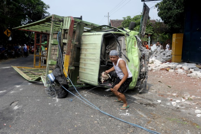 DIEVAKUASI: Petugas dibantu warga melakukan evakuasi truk laka lantas di Jalan Windurejo, Kecamatan Kutorejo, Kamis (25/8). (Sofan Kurniawan/Jawa Pos Radar Mojokerto)