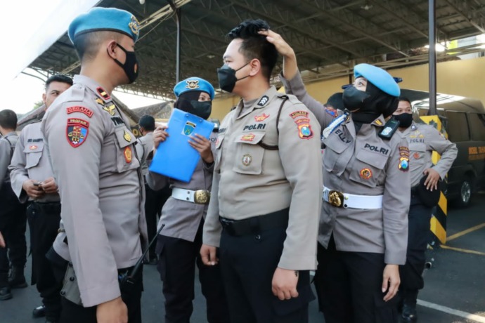 DITEGUR: Seorang anggota Polres Mojokerto Kota kedapatan berambut panjang saat operasi gaktiplin, kemarin.