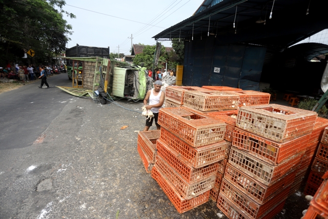 DIEVAKUASI: Petugas dibantu warga melakukan evakuasi truk laka lantas di Jalan Windurejo, Kecamatan Kutorejo, Kamis (25/8). (Sofan Kurniawan/Jawa Pos Radar Mojokerto)
