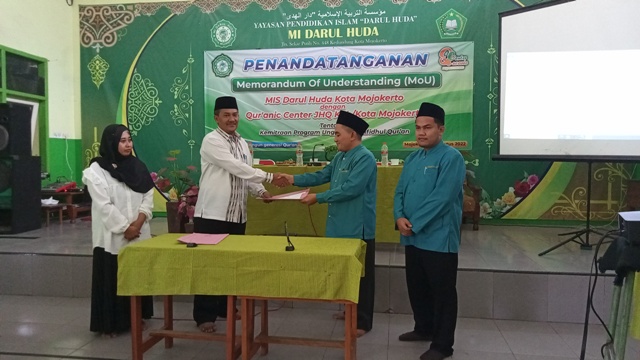 SEPAKAT: Kepala MI Darul Huda dan Ketua Quranic Center JHQ Mojokerto menandatangi MoU kemitraan program unggulan tahfiz bertepatan dengan hari Kemerdekaan RI Ke-77.