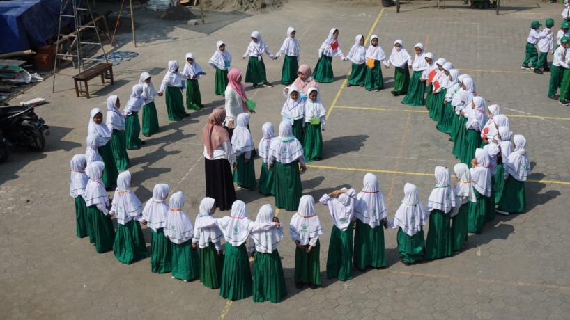 BERSEMANGAT: Guru membimbing peserta didik baru MI Darul Huda saat bermain game perkenalan diri sesama teman.