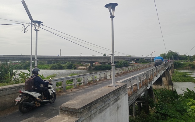 TUA: Pengendara melintas di Jembatan Pagerluyung, Kecamatan Gedeg, Kabupaten Mojokerto. Beragam cerita mistis terkait jalur alternatif ini berkembang di masyarakat. (Yulianto Adi Nugroho/Jawa Pos Radar Mojokerto)