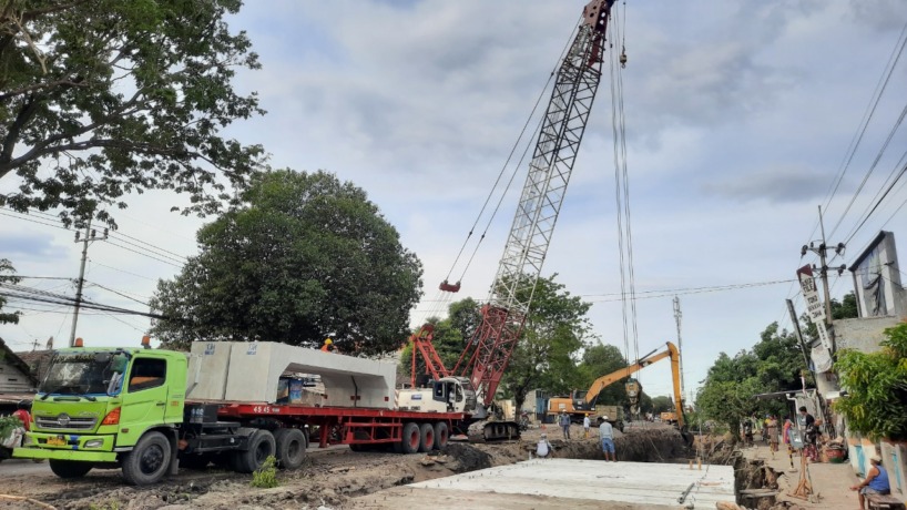 DIKEBUT: Sejumlah pekerja memasang box culvert menggunakan alat berat pada proyek peningkatan Jalan Empunala, Kota Mojokerto, Minggu (4/9).