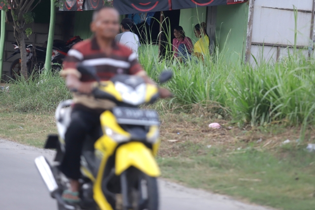 DIPANTAU: Pengendara melintas di depan warung yang diduga menjajakan layanan seksual di Desa Jatirowo, Kecamatan Dawarblandong, kemarin (14/9). (Sofan Kurniawan/Jawa Pos Radar Mojokerto)