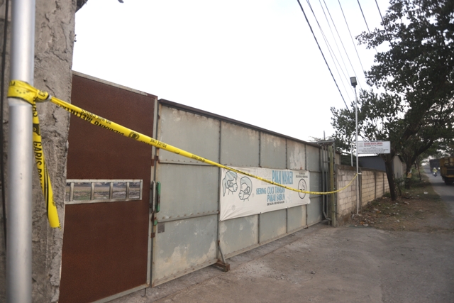STERIL: Garis polisi terpasang di pintu masuk PT Prodina Jawara Group di Desa Jatirowo, Kecamatan Dawarblandong, yang terbakar pekan lalu. (Yulianto Adi Nugroho/Jawa Pos Radar Mojokerto)